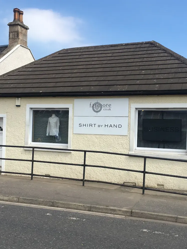 Shop window displaying a handmade white shirt beneath a Shirt By Hand sign